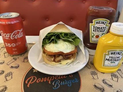 Burger com alface, ovo e bacon ao lado de ketchup e mostarda